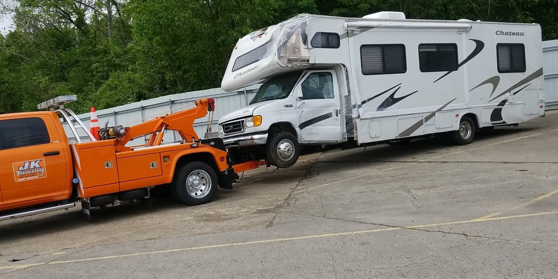 JK Towing's tow truck uses its under-lift boom to tow a motor home